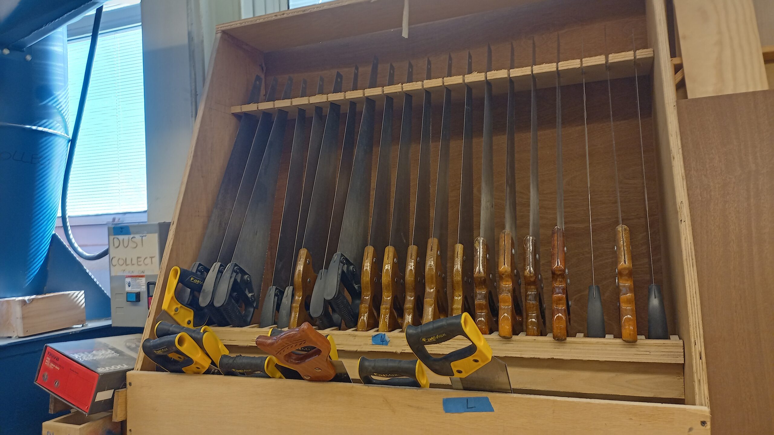 Organized hand tools stored on wall in shop classroom
