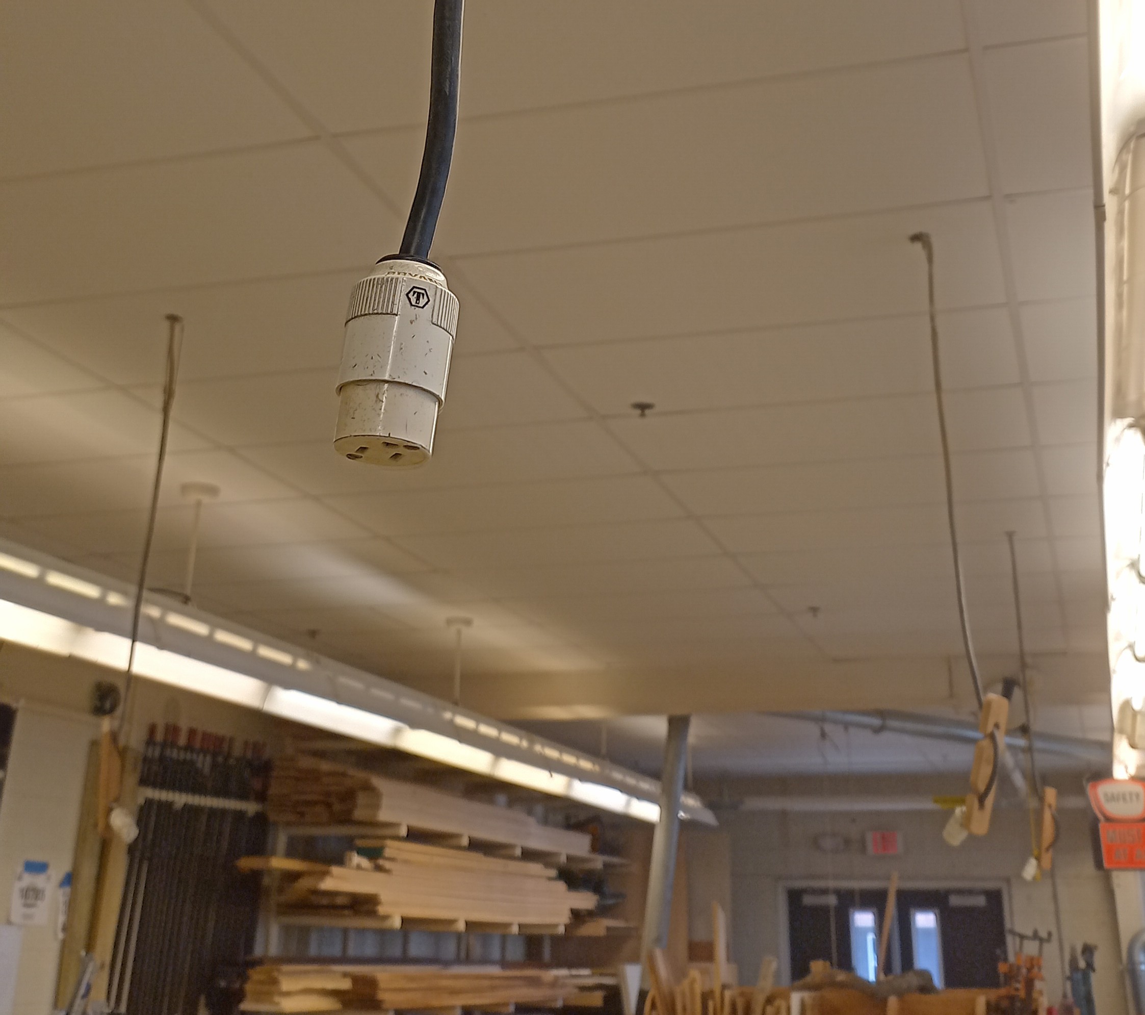 Overhead electrical outlets hanging above classroom work tables
